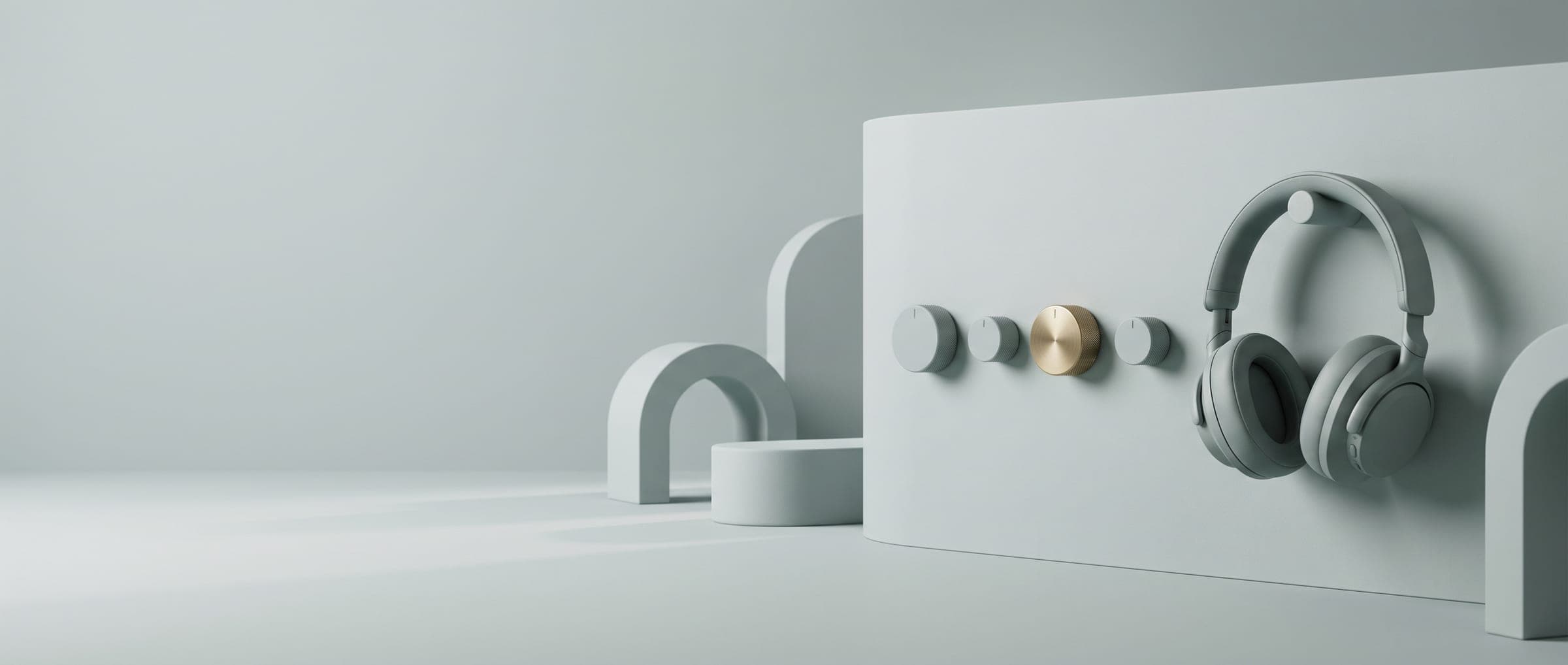 A row of control knobs and a pair of headphones on a grey-green wall panel